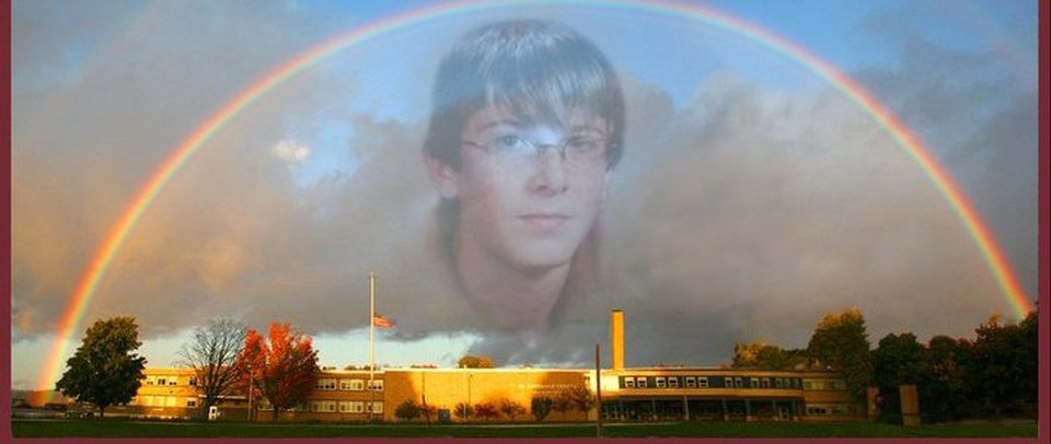 Rainbow stretching over Brasher Falls / St. Lawrence Central High School, with flag at half mast and Kyle Cootware's face Photoshopped over the clouds